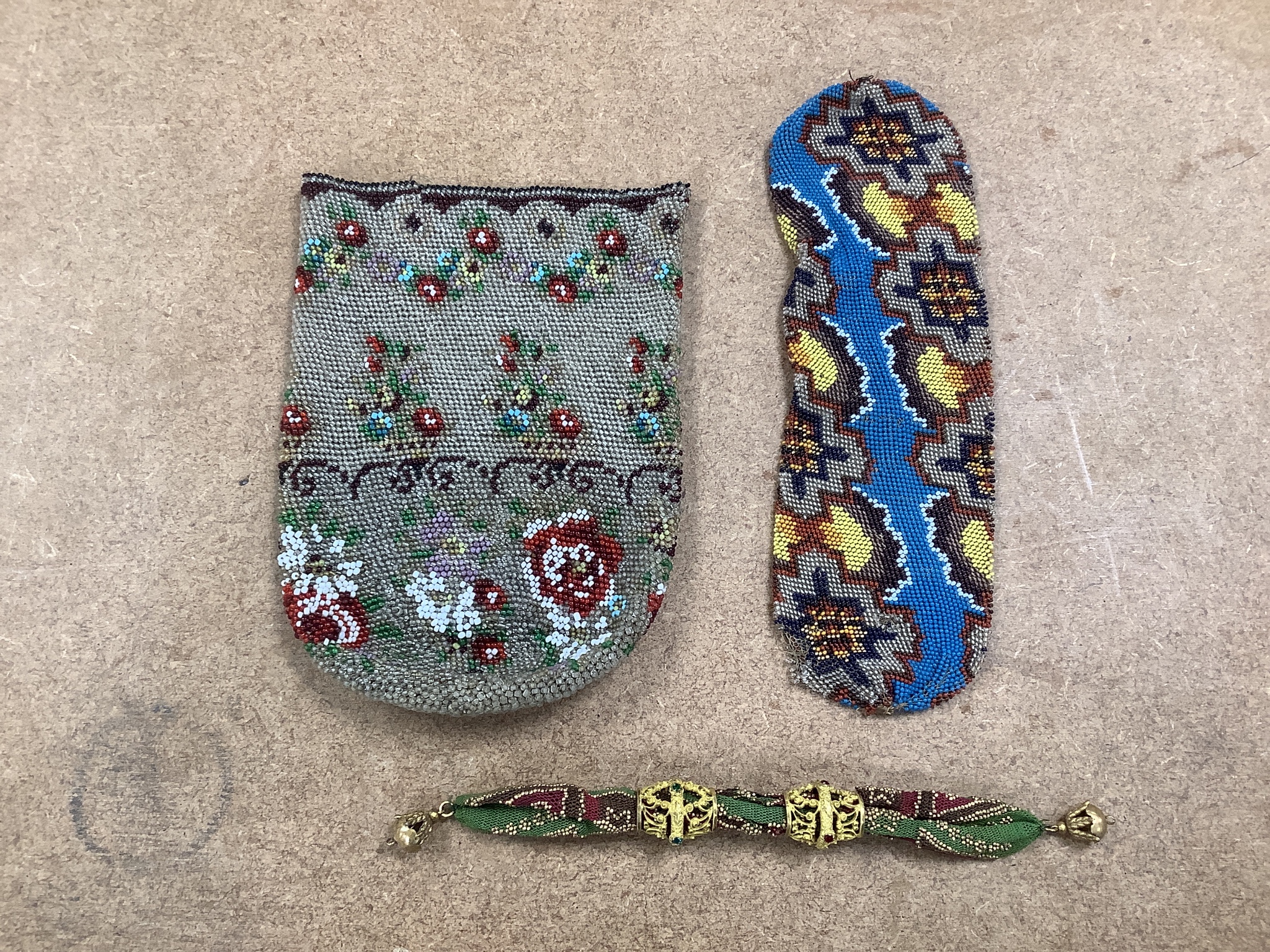 An unusual early 19th century cut steel misers purse with ornate jewelled gilt metal bands, another similar purse, two other brightly beaded misers purses and a further quantity of metal framed beadwork purses and a bag